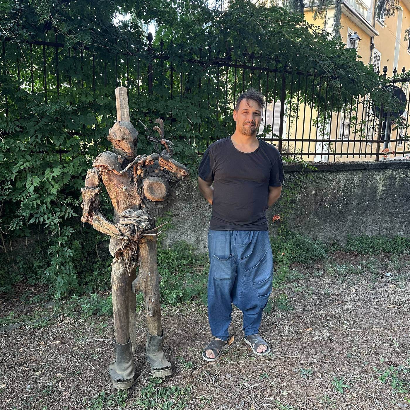 Gualtiero Fulvio Caiafa naast een van zijn houten sculpturen