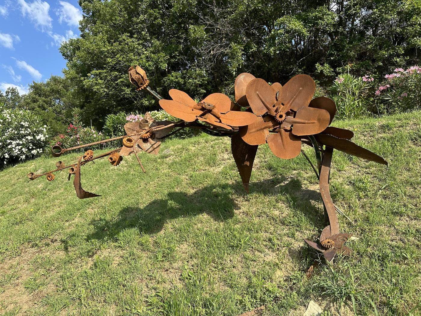 IJzeren bloem-sculptuur van Gualtiero Fulvio Caiafa tussen de oleanders bij het zwembad van Casa Mumu