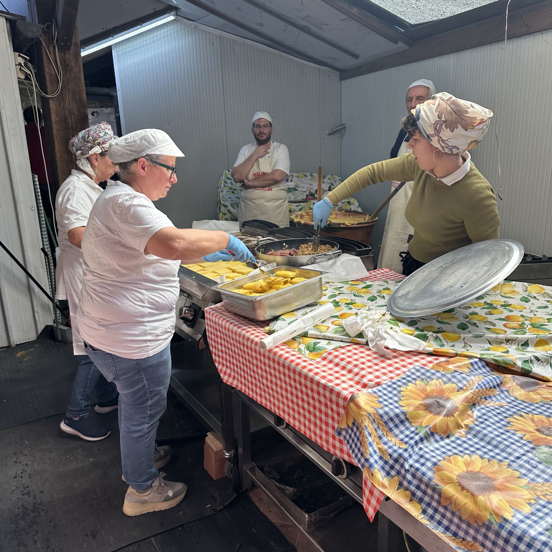 Vrijwilligers uit het dorp bereiden de polenta in de veldkeuken