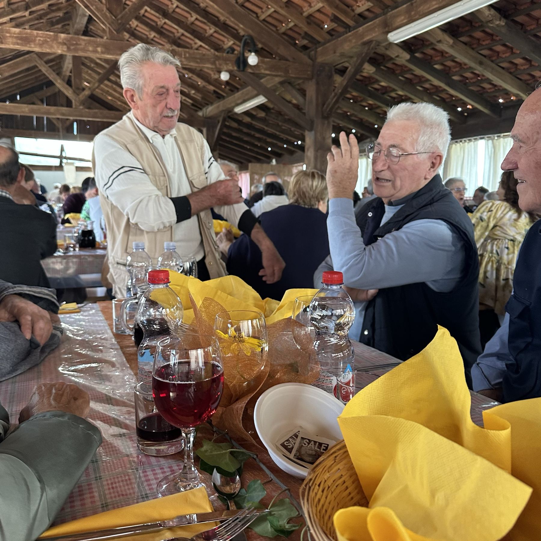 Dorpsgenoten in gesprek aan de lange tafels tijdens het polentafeest
